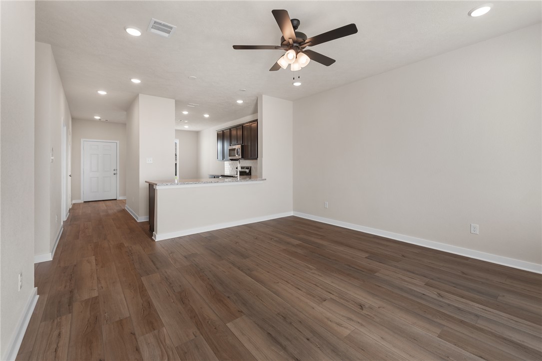 2427 Rooke Road Bryan, TX 77807 - Photo 21 of 38 a view of a livingroom with a hardwood floor and a ceiling fan