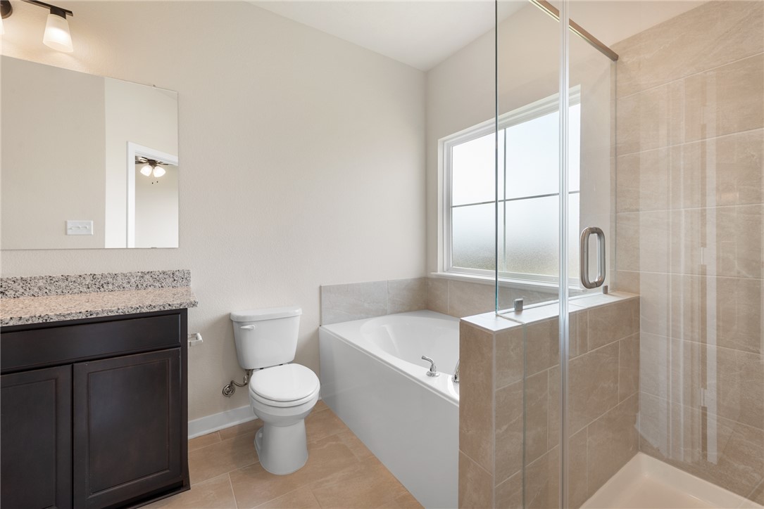 2427 Rooke Road Bryan, TX 77807 - Photo 32 of 38 a bathroom with a granite countertop sink a toilet and tub