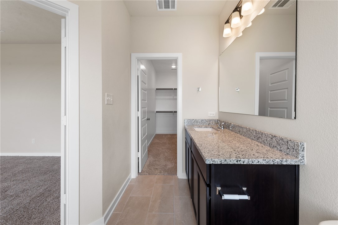 2427 Rooke Road Bryan, TX 77807 - Photo 33 of 38 a bathroom with a granite countertop sink and a mirror