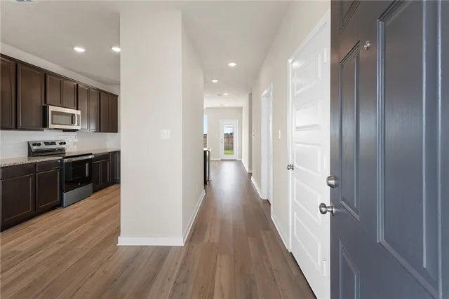 a view of a kitchen with a sink and dishwasher a refrigerator with wooden floor
