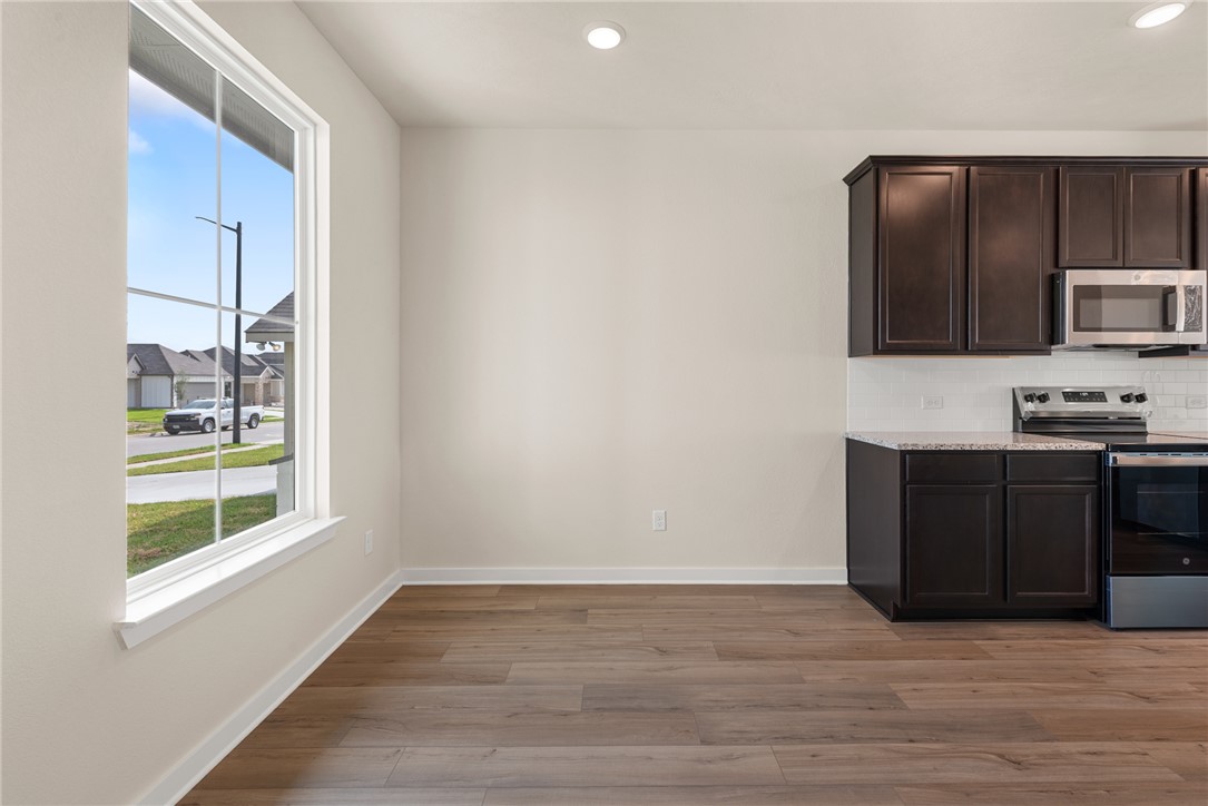 2427 Rooke Road Bryan, TX 77807 - Photo 6 of 38 a kitchen with granite countertop a refrigerator and a stove top oven