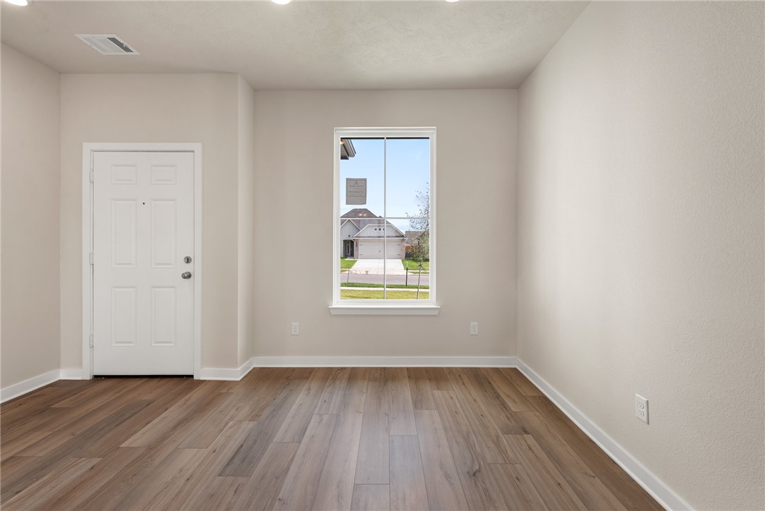 2427 Rooke Road Bryan, TX 77807 - Photo 8 of 38 a view of an empty room with wooden floor and window