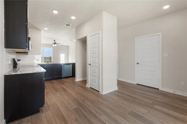 a view of kitchen with wooden floor and electronic appliances