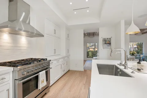 a kitchen with stainless steel appliances a sink stove and cabinets