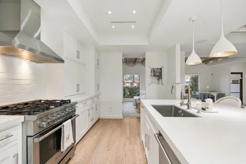 a kitchen with stove a sink and cabinets