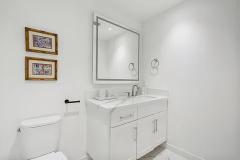 a bathroom with a toilet sink and mirror