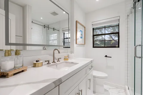 a bathroom with a sink a toilet and mirror