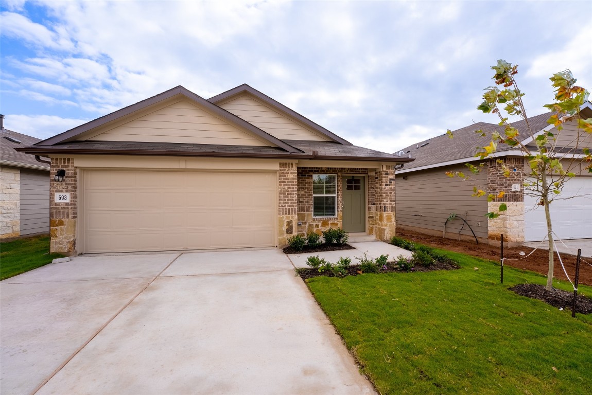 a front view of a house with a garden and yard