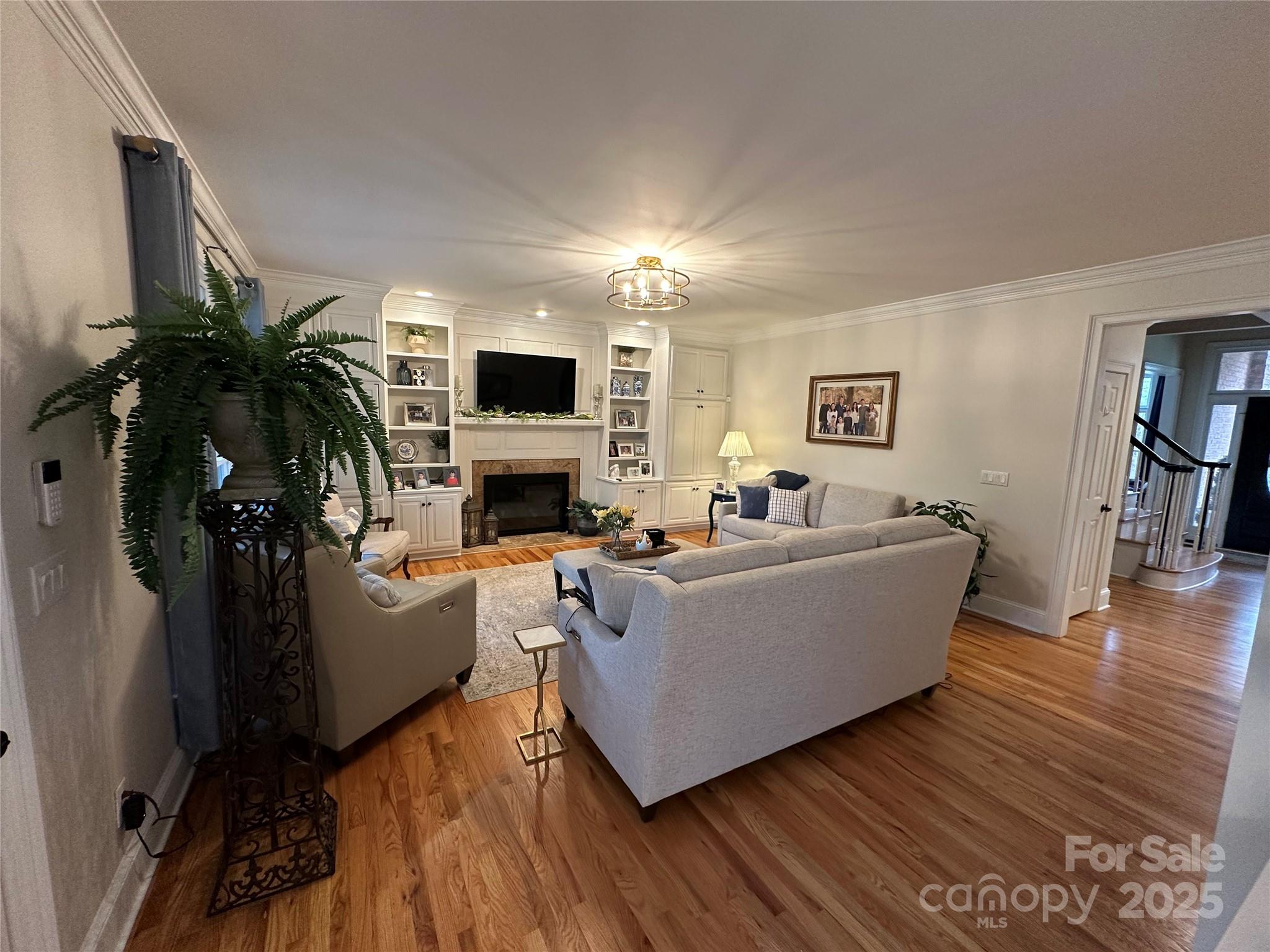 19622 River Falls Drive Davidson, NC 28036 - Photo 6 of 25 a living room with furniture a fireplace a flat screen tv and potted plant