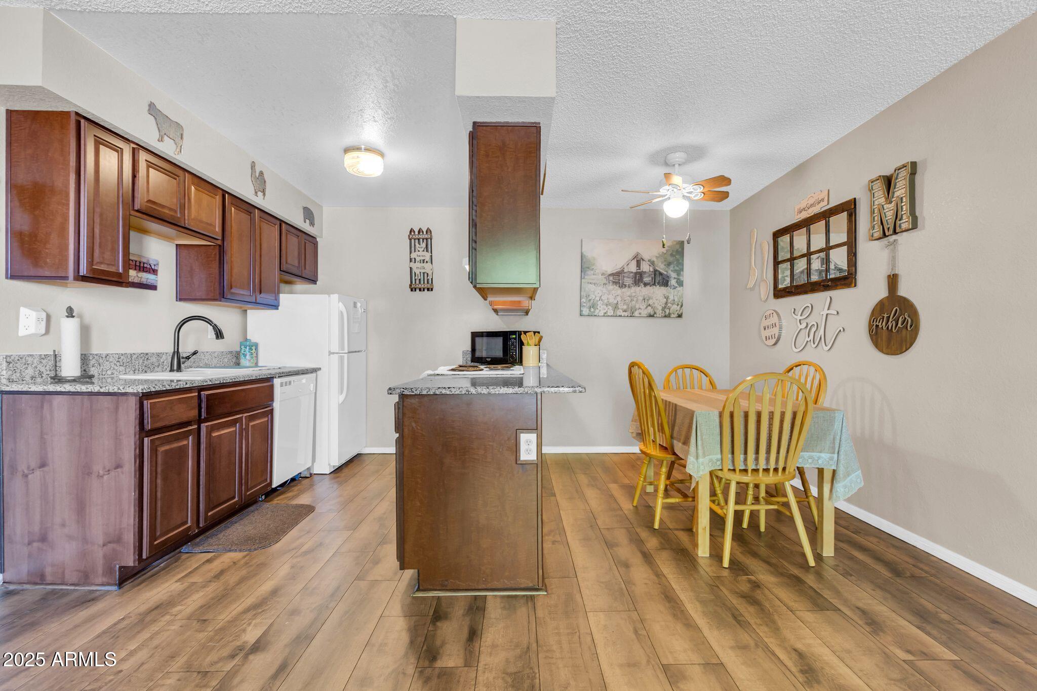 1440 North Idaho Road, Unit 2060 Apache Junction, AZ 85119 - Photo 1 of 24 a living room with stainless steel appliances granite countertop furniture wooden floor and a kitchen view