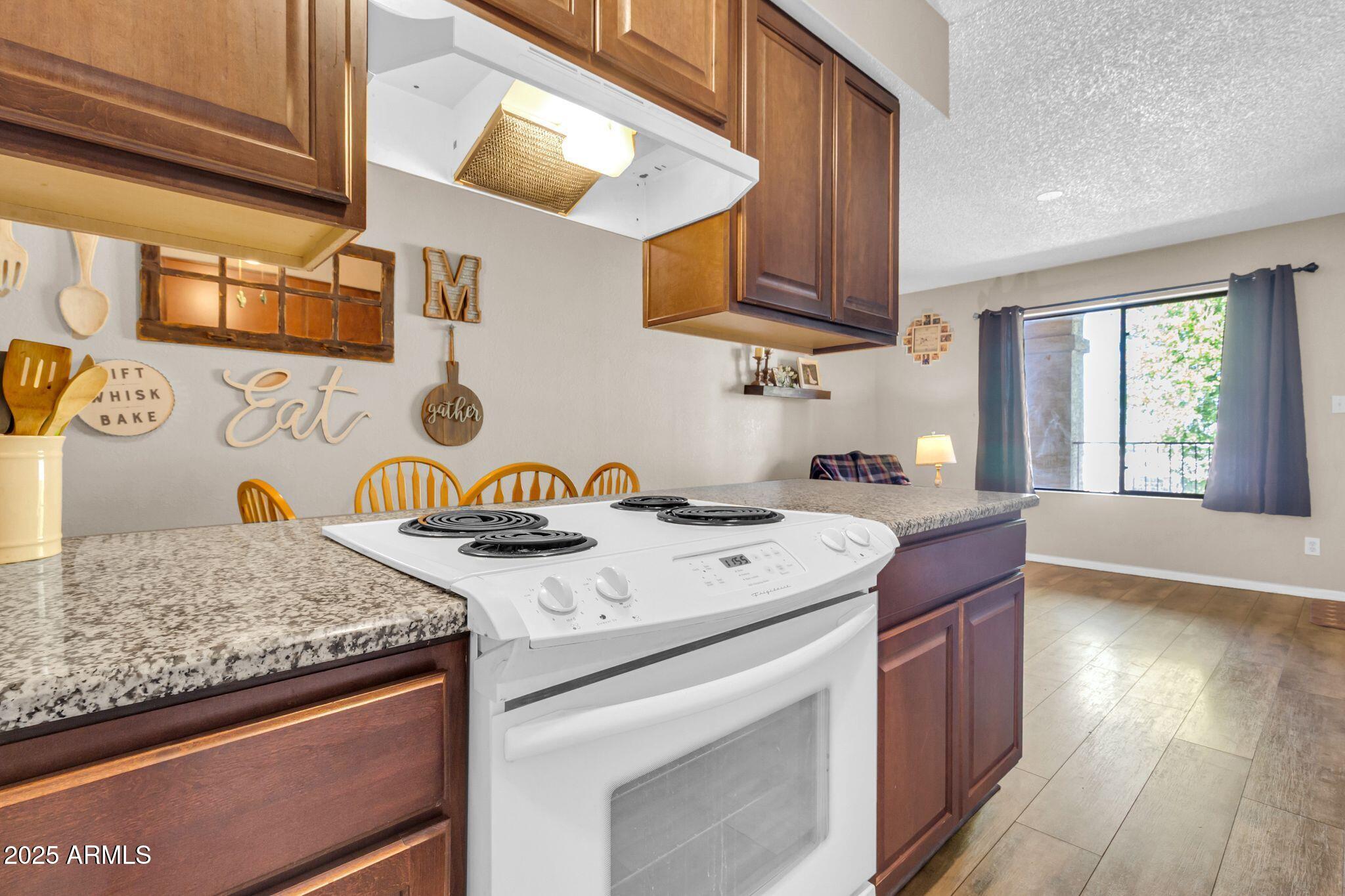 1440 North Idaho Road, Unit 2060 Apache Junction, AZ 85119 - Photo 11 of 24 a kitchen with stainless steel appliances granite countertop a sink stove and cabinets