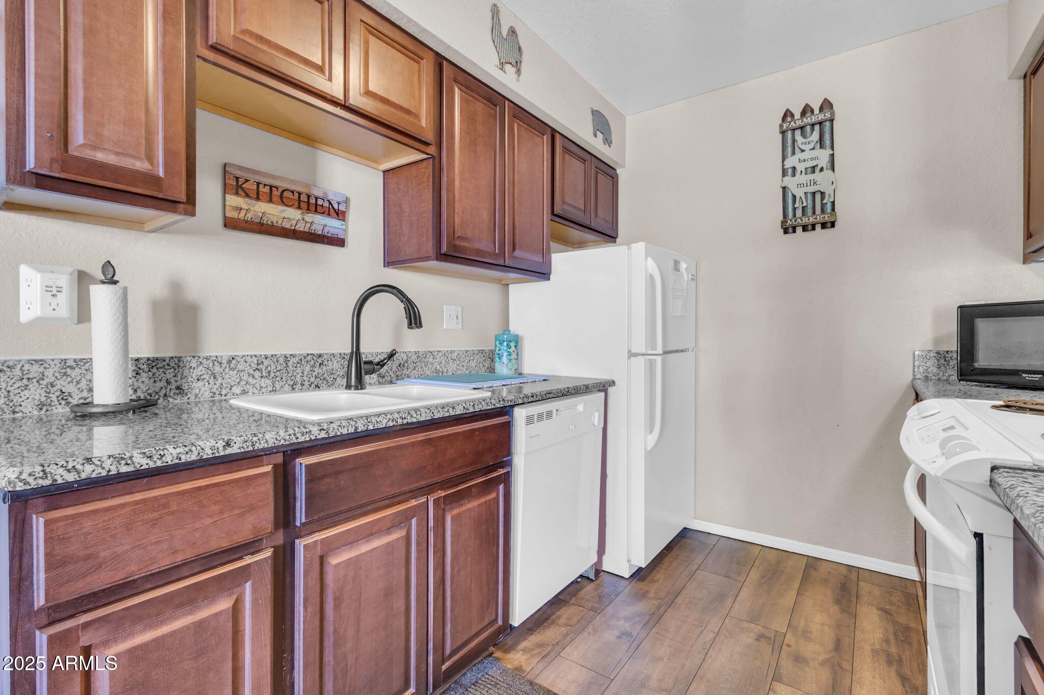 1440 North Idaho Road, Unit 2060 Apache Junction, AZ 85119 - Photo 13 of 24 a kitchen with stainless steel appliances granite countertop a sink stove and refrigerator