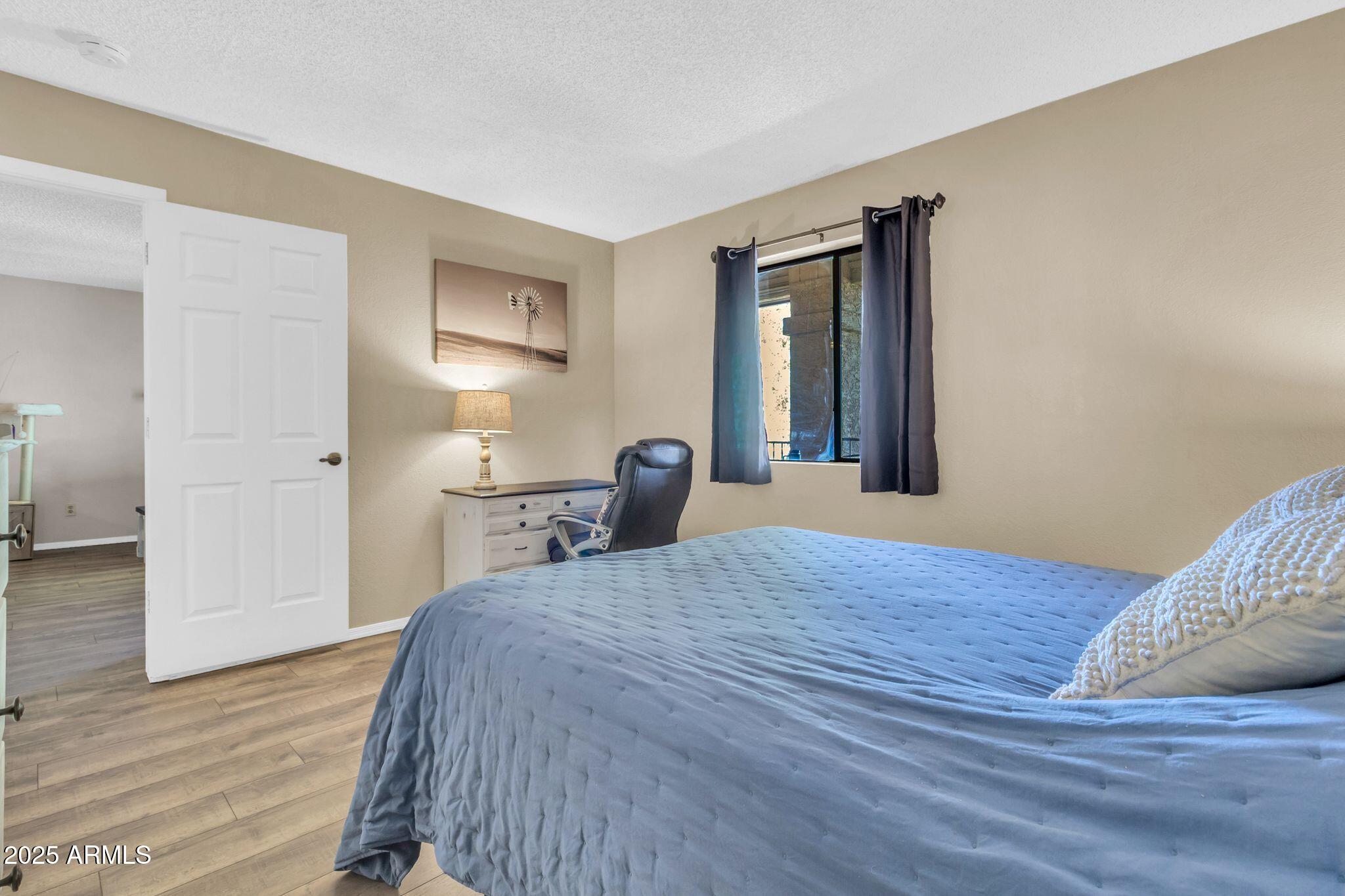 1440 North Idaho Road, Unit 2060 Apache Junction, AZ 85119 - Photo 15 of 24 a bedroom with a bed and a painting on the wall