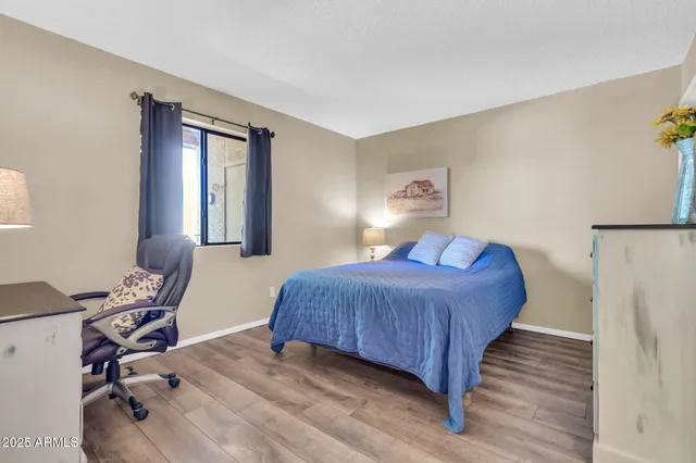 a bedroom with a bed and a painting on the wall