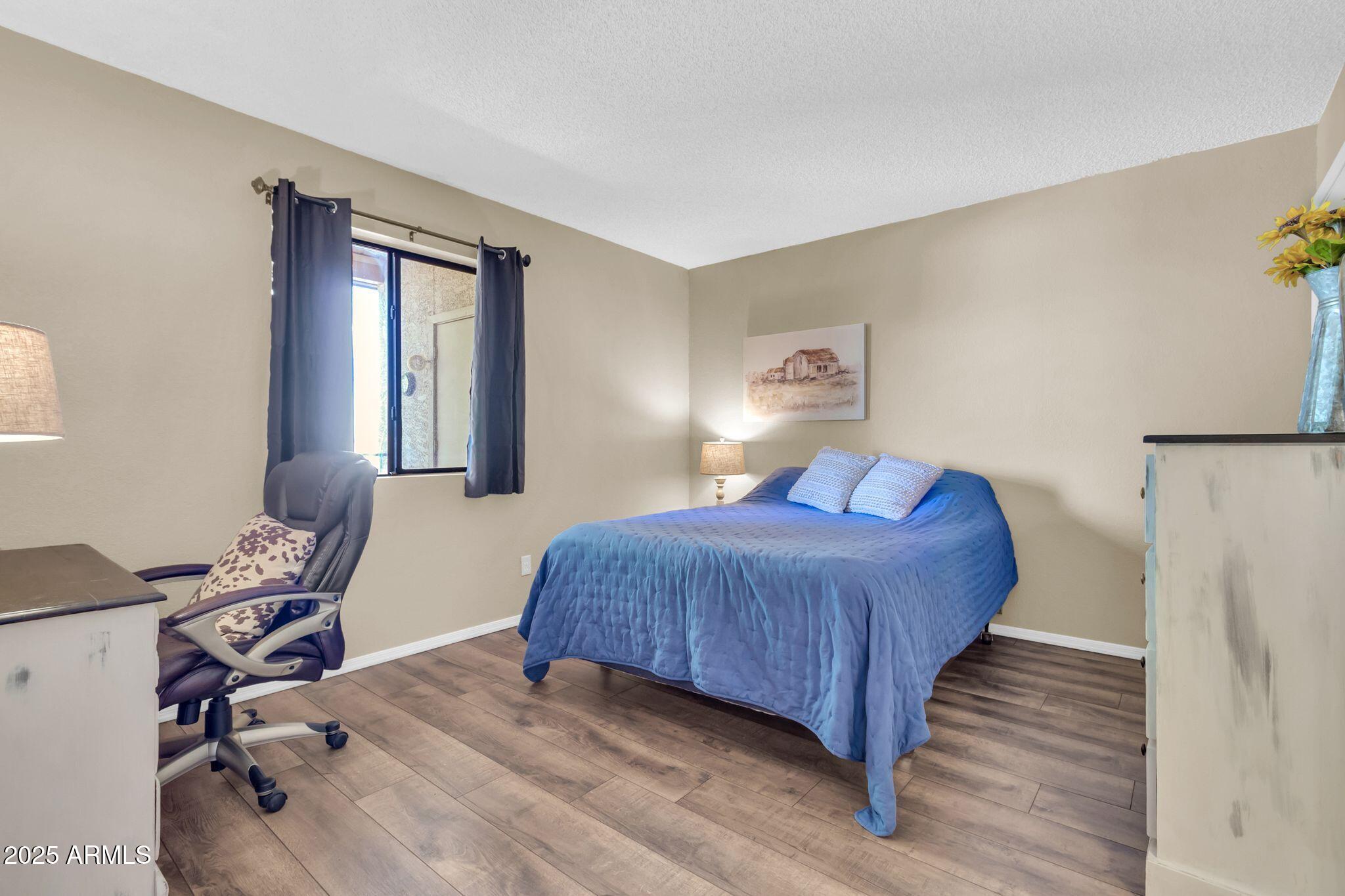 1440 North Idaho Road, Unit 2060 Apache Junction, AZ 85119 - Photo 16 of 24 a bedroom with a bed a chair and a large window