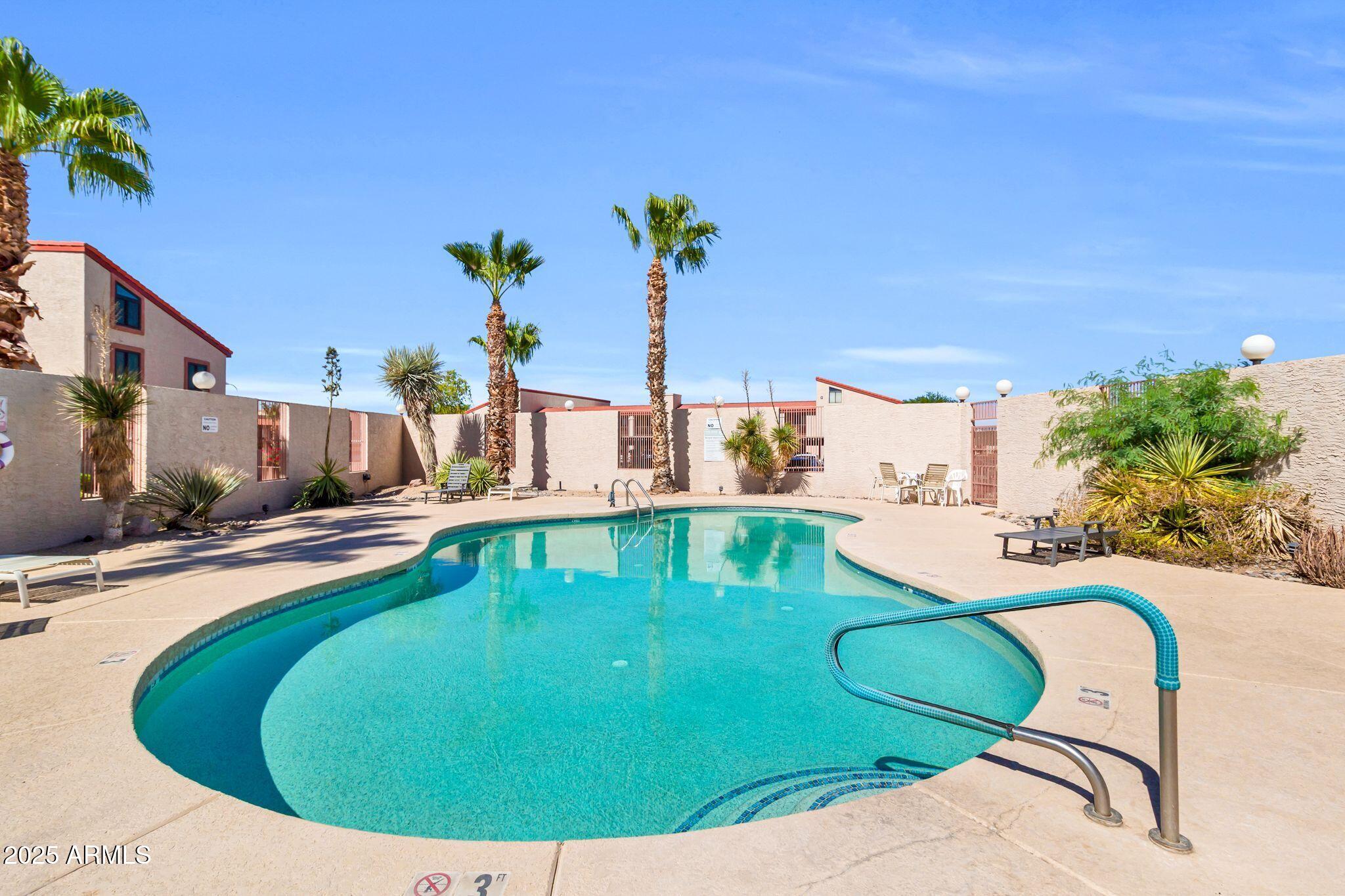 1440 North Idaho Road, Unit 2060 Apache Junction, AZ 85119 - Photo 5 of 24 a view of a swimming pool with a yard