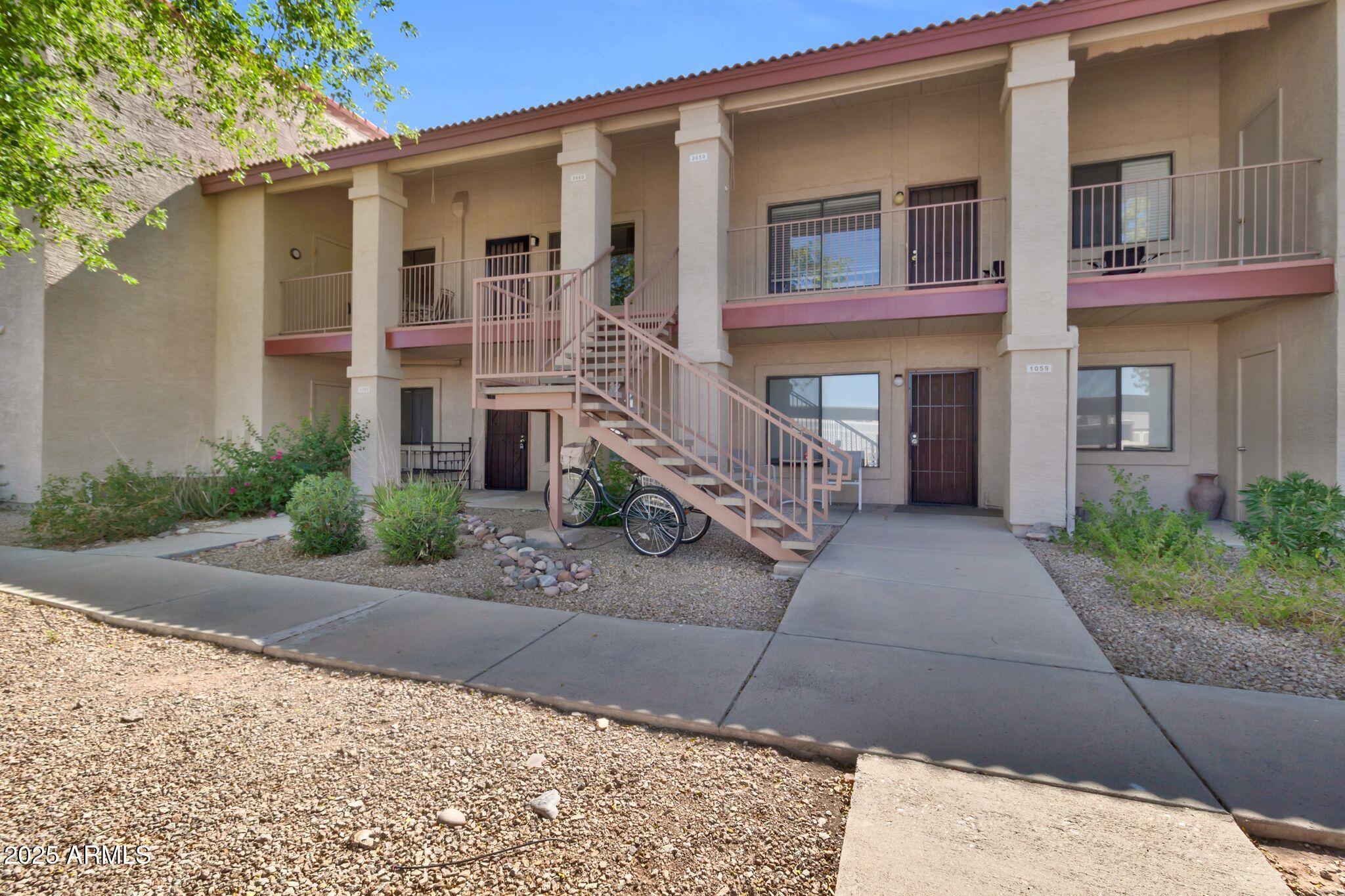 1440 North Idaho Road, Unit 2060 Apache Junction, AZ 85119 - Photo 7 of 24 a front view of a house with a yard and a garage