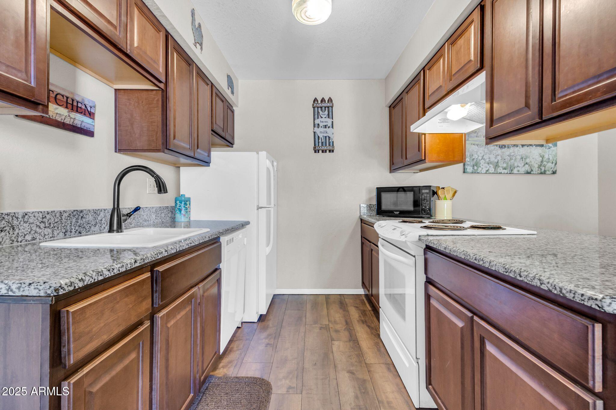 1440 North Idaho Road, Unit 2060 Apache Junction, AZ 85119 - Photo 9 of 24 a kitchen with stainless steel appliances granite countertop a sink stove and cabinets