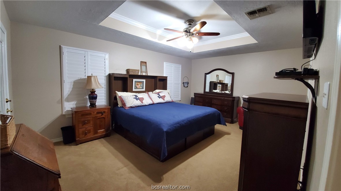 5660 Falling Water Bryan, TX 77808 - Photo 6 of 27 Bedroom featuring ornamental molding, light colored carpet, ceiling fan, and a tray ceiling