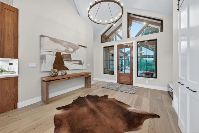 a large kitchen with kitchen island a island a stove a sink dishwasher a refrigerator and a dining table with wooden floor