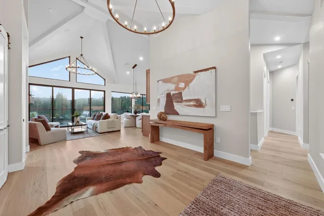 a kitchen with a stove a sink a counter top space and living room view