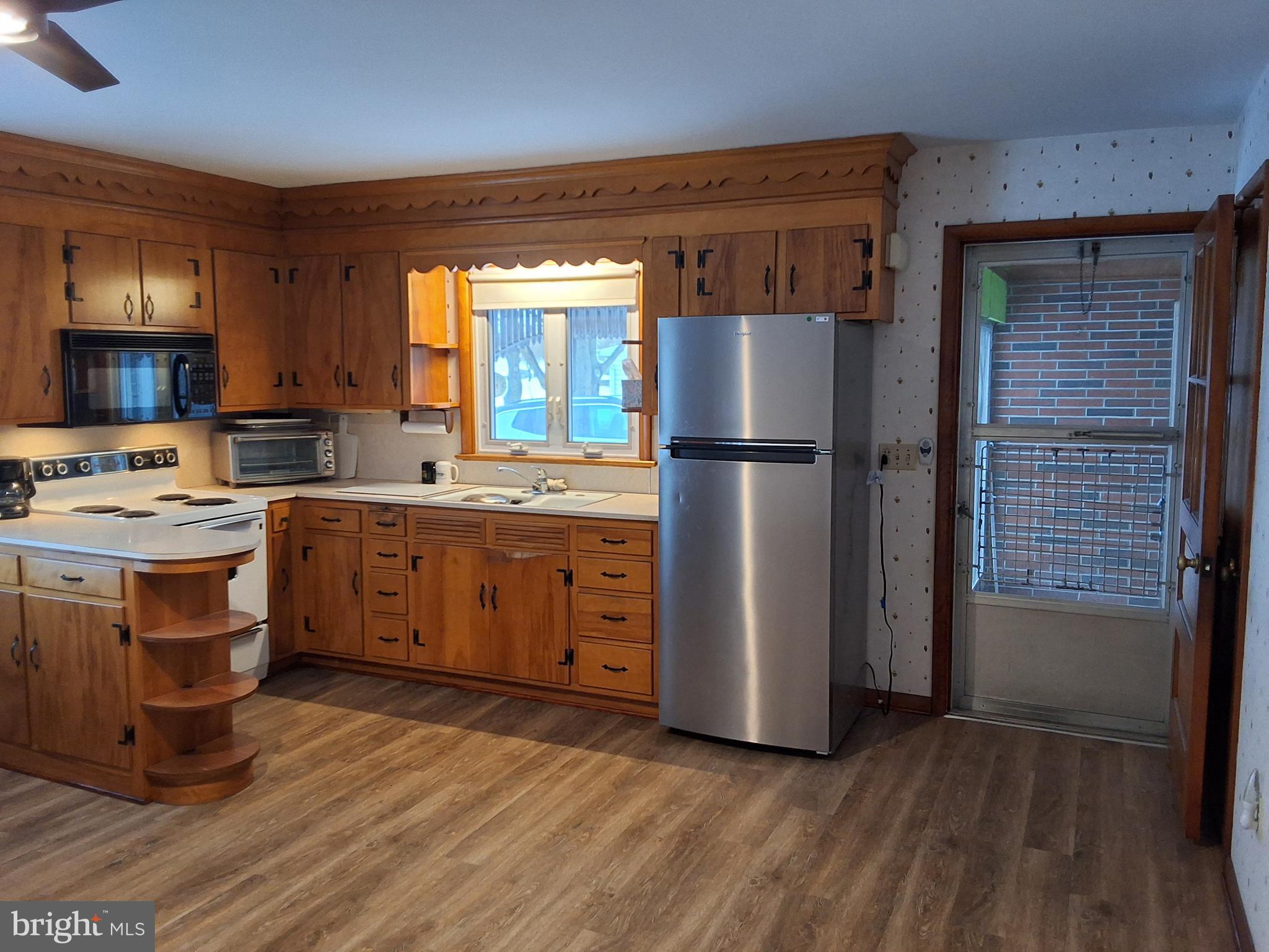 130 Fairland Road Lititz, PA 17543 - Photo 9 of 22 a kitchen with a refrigerator a stove top oven a sink and dishwasher with wooden floor
