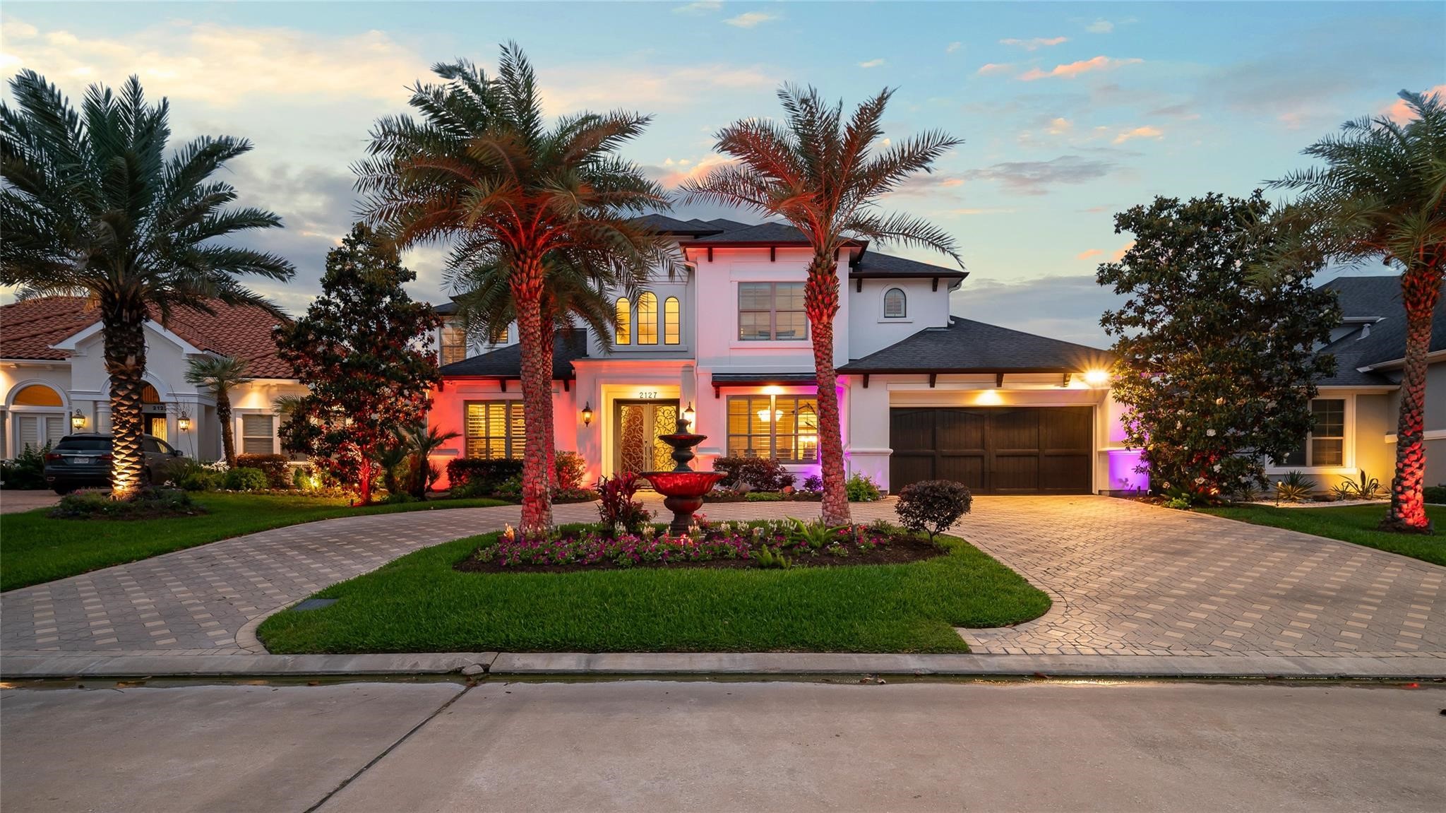 2127 Thicket Ridge Lane Houston, TX 77077 - Photo 4 of 50 Gorgeous curb appeal with custom uplighting, brick paver driveway, stately cold hardy palms, magnificent magnolia trees, custom wrought iron double front doors and wood garage door.