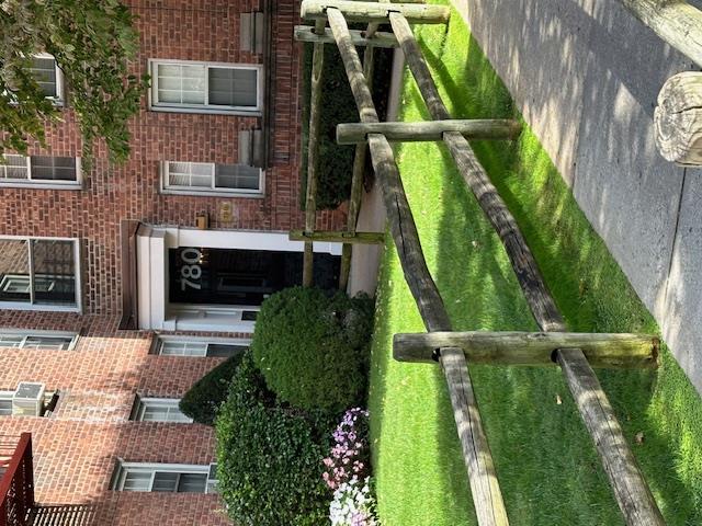 780 Bronx River Road, Unit A58 Bronxville, NY 10708 - Photo 1 of 1 View of exterior entry featuring cooling unit and a yard