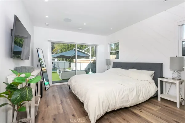a bedroom with a large bed and a potted plant