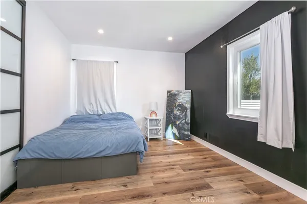 a bedroom with a bed and wooden floor
