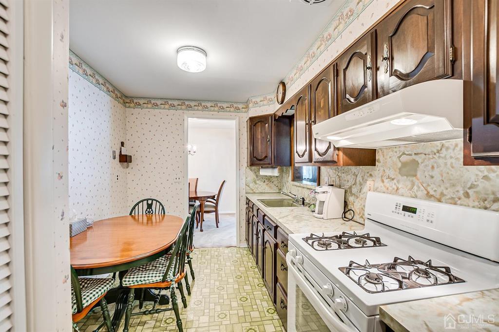 6 Frederick Avenue Colonia, NJ 07067 - Photo 13 of 33 a kitchen with a table chairs stove and cabinets