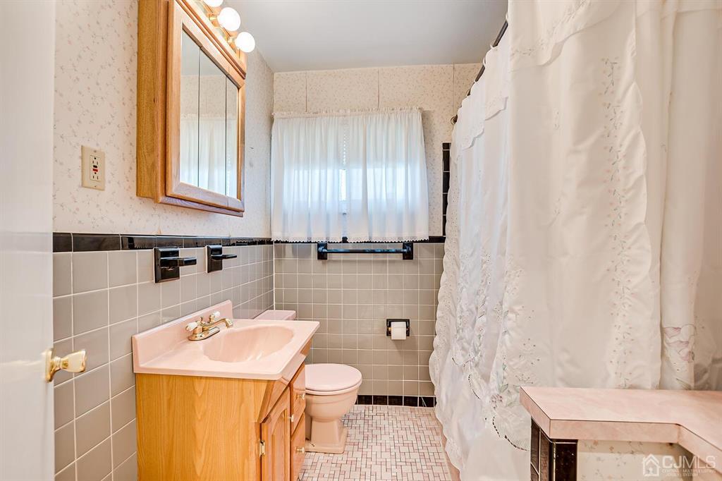 6 Frederick Avenue Colonia, NJ 07067 - Photo 23 of 33 a bathroom with a sink a toilet and shower curtain