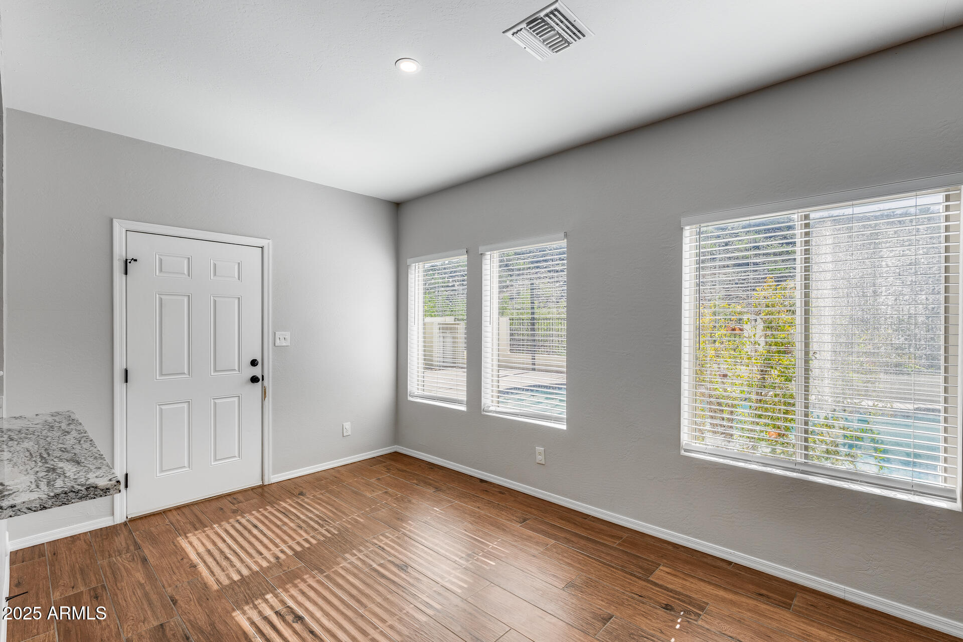 14452 South 40th Street Phoenix, AZ 85044 - Photo 31 of 92 a view of an empty room with a window and wooden floor