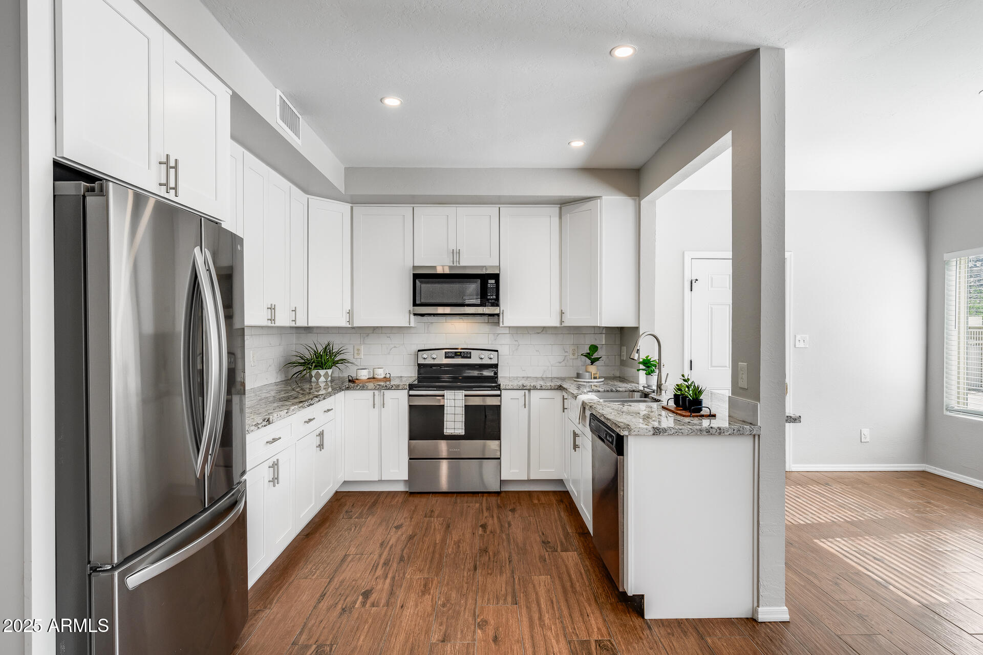 14452 South 40th Street Phoenix, AZ 85044 - Photo 35 of 92 a kitchen with white cabinets and stainless steel appliances
