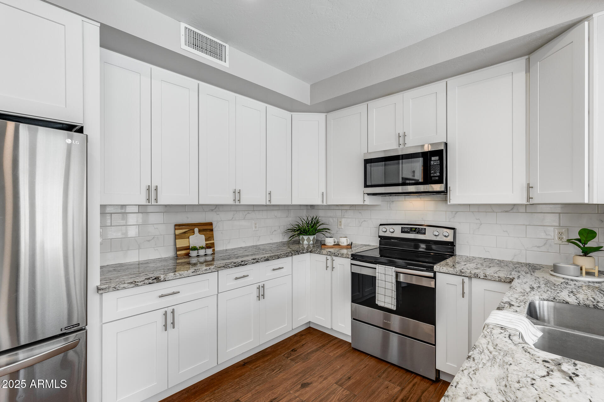 14452 South 40th Street Phoenix, AZ 85044 - Photo 5 of 92 a kitchen with granite countertop white cabinets sink and stainless steel appliances