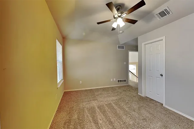 a view of an empty room and a ceiling fan