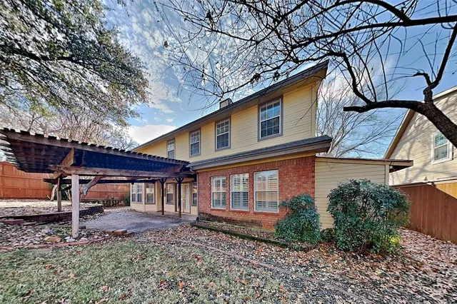 a backyard of a house with table and chairs