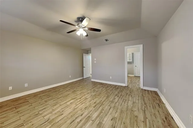 a view of an empty room with wooden floor