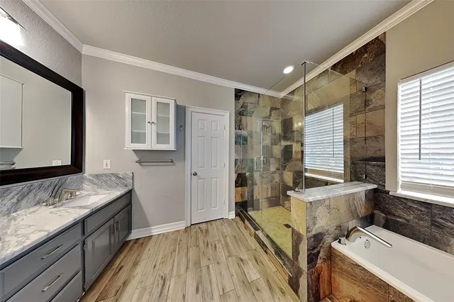 a spacious bathroom with a granite countertop sink a mirror and a bathtub