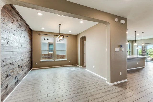 a view of a hallway with wooden floor and a living room