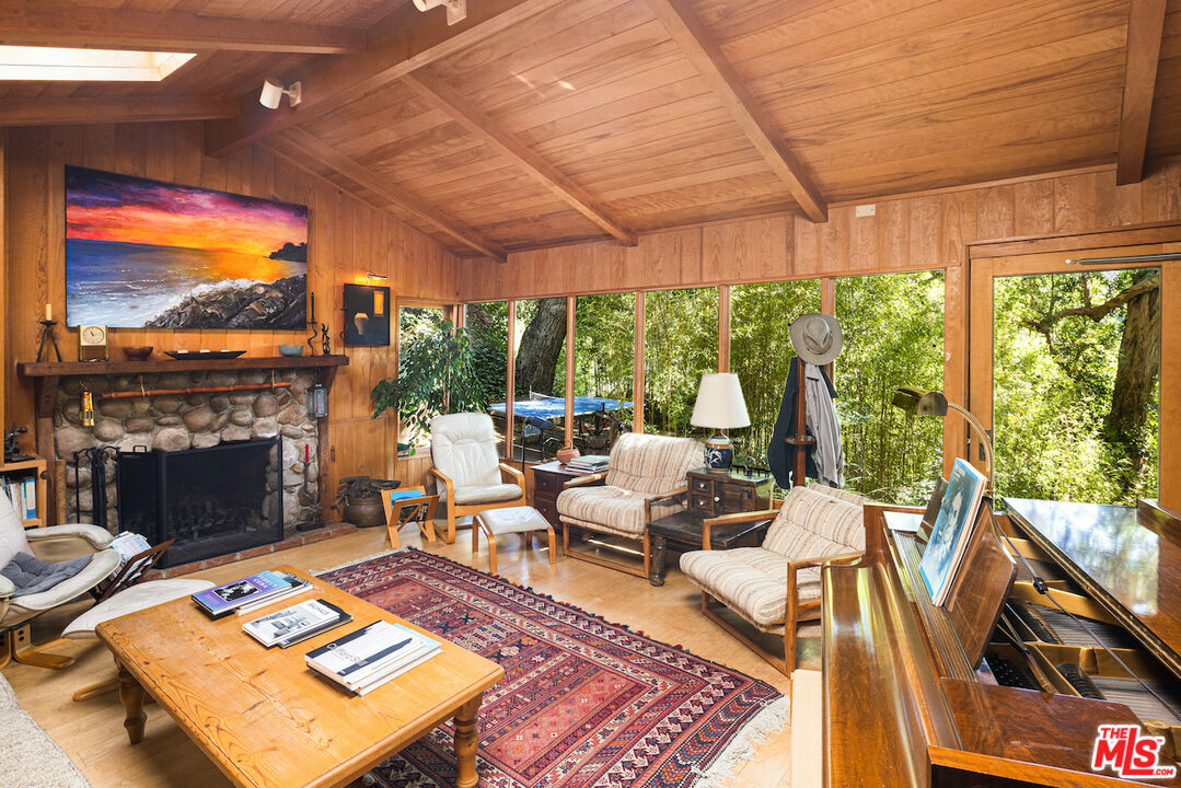 537 West Rustic Road Santa Monica, CA 90402 - Photo 3 of 22 a living room with furniture a fireplace and a floor to ceiling window
