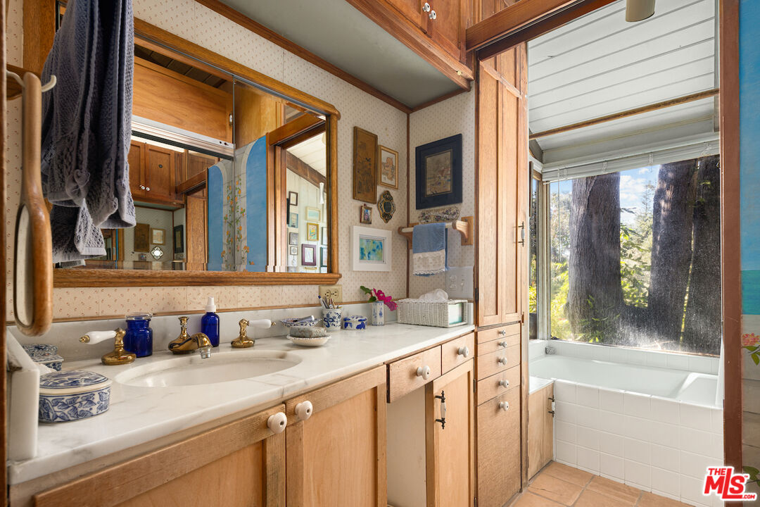 537 West Rustic Road Santa Monica, CA 90402 - Photo 9 of 22 a bathroom with a granite countertop sink and a large mirror