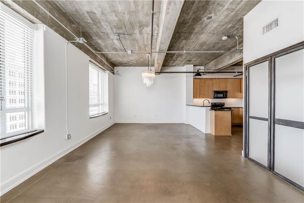 710 Colorado Street, Unit G9 Austin, TX 78701 - Photo 15 of 25 The open-concept layout features durable concrete flooring, blending urban style with a minimalist aesthetic.