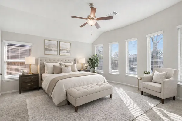 a spacious bedroom with a bed and a couch next to a window