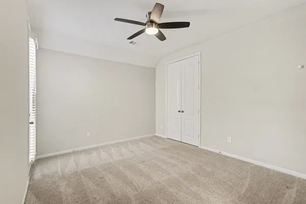 a view of a room with a ceiling fan and a ceiling fan