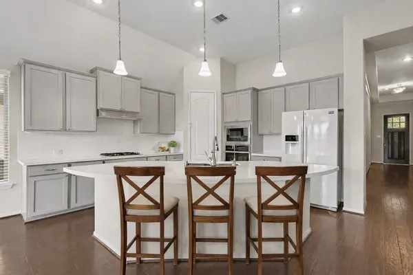 a kitchen with stainless steel appliances granite countertop a kitchen island a stove a table and chairs in it