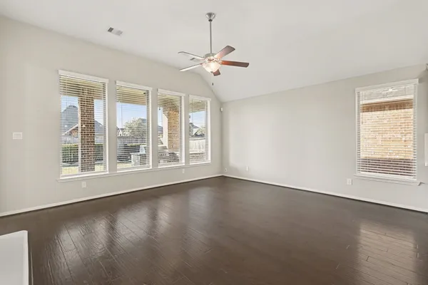 a view of wooden floor and a chandelier fan in a room