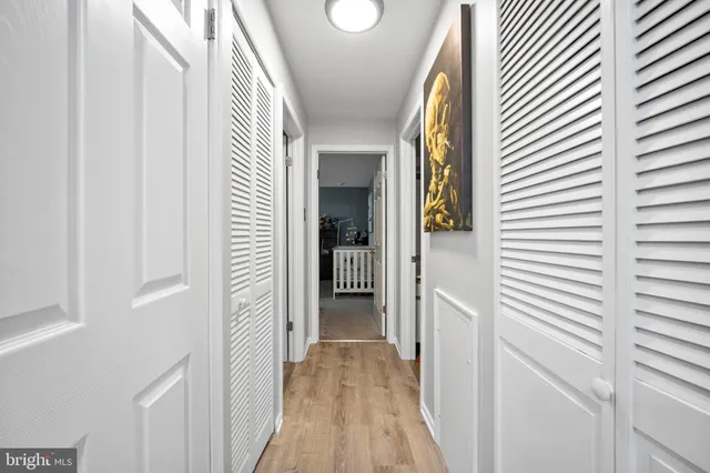 a view of a hallway with wooden floor and windows