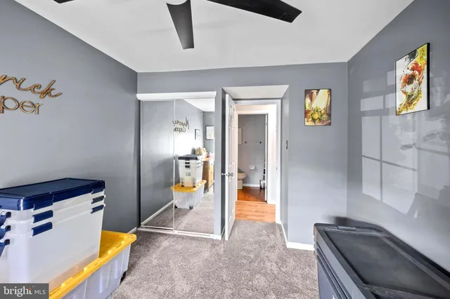 a bed sitting in a bedroom next to a flat screen tv with a bookshelf