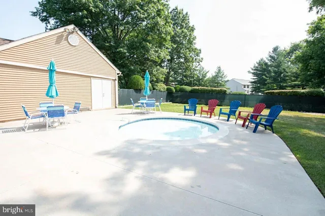 a view of a swimming pool with a lawn chairs and a small yard